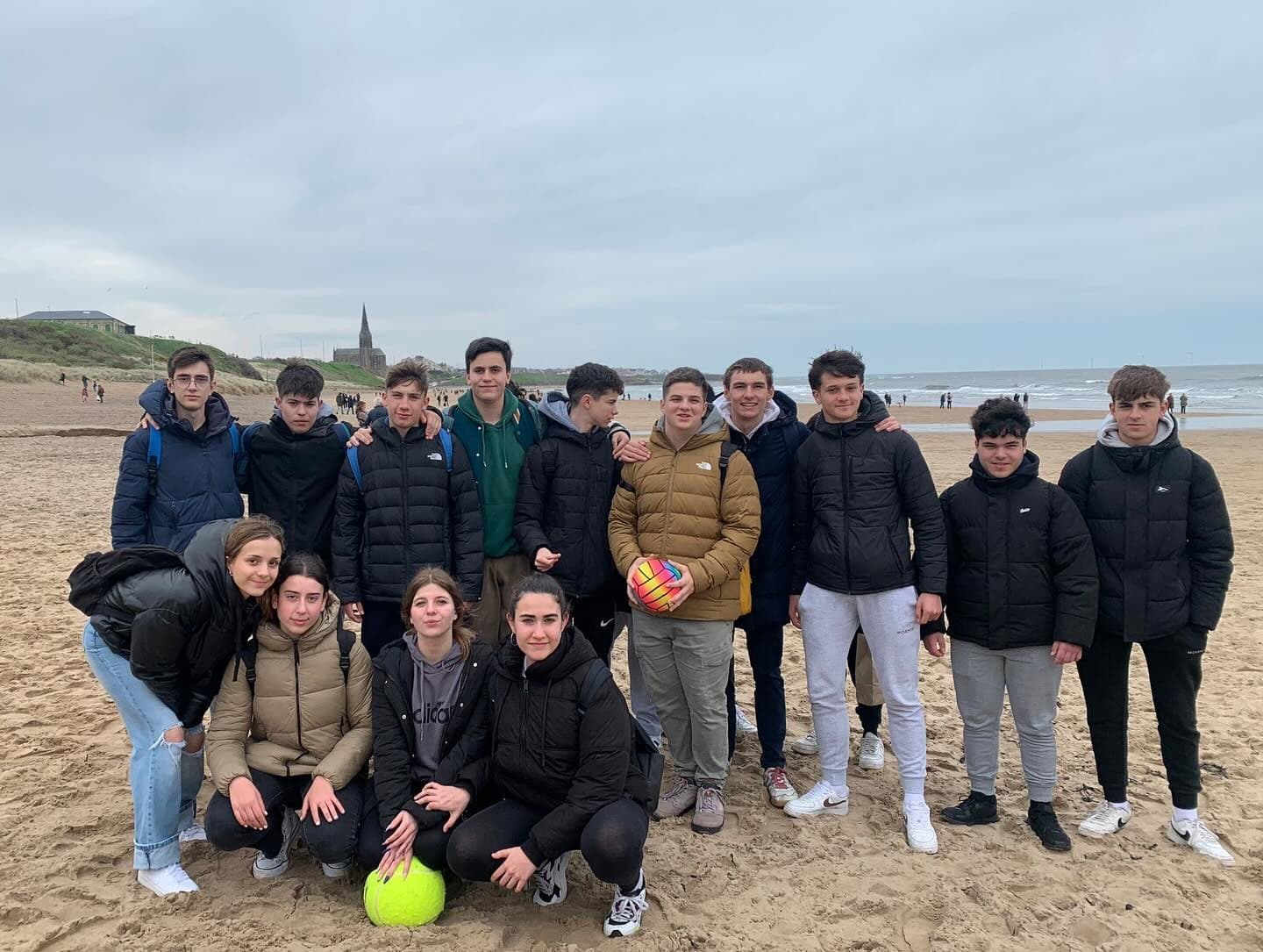 Students on the beach at Tynemouth, wrapped up against the North Sea wind