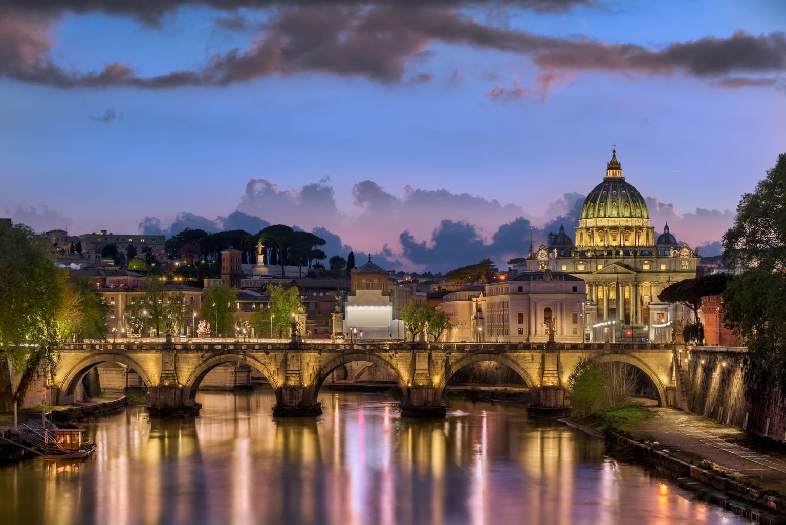 St Peter's dome and Ponte Sant'Angelo over the Tiber in Rome at dusk
